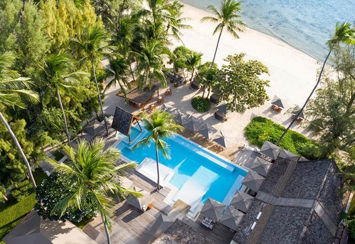 Aerial view of SALA Samui Choengmon Beach, a gay-friendly hotel. Pool, beach, palm trees, and bungalows offer a tropical escape.