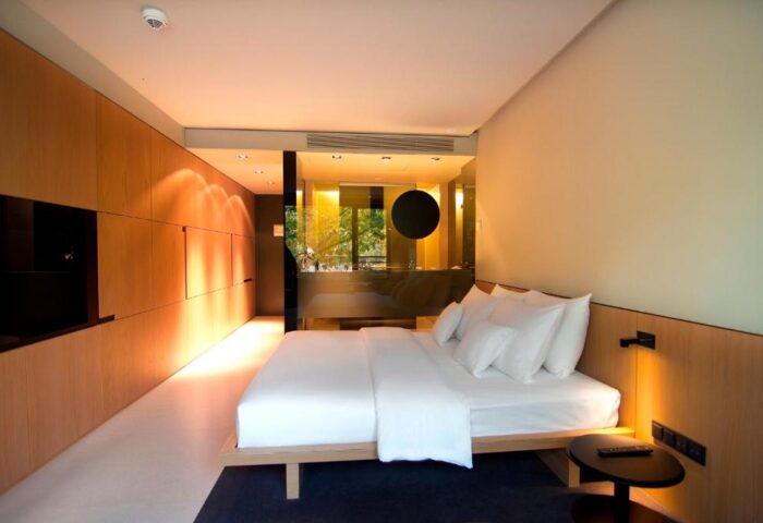 SANA Berlin Hotel room. Modern, bright interior with bed, wood paneling, and bathroom. Gay-friendly, pet-friendly hotel in Berlin.