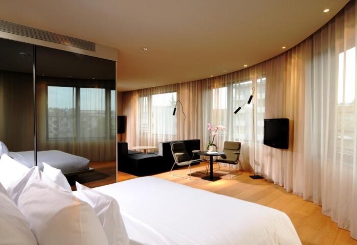 SANA Berlin Hotel room interior. Gay-friendly, pet-friendly hotel features modern decor, seating area, and a bright, airy ambiance.