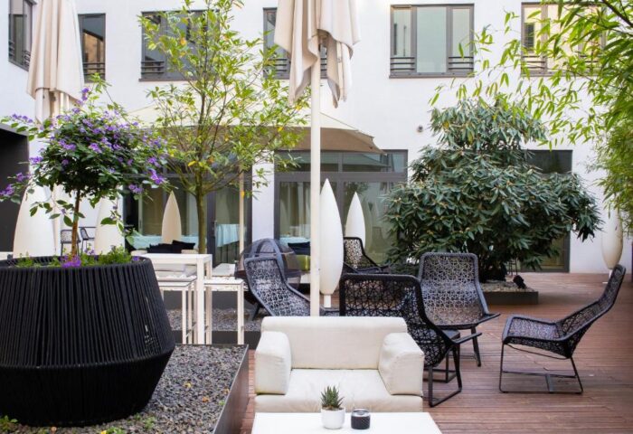SANA Berlin Hotel's courtyard. Gay-friendly, pet-friendly hotel with outdoor seating, plants, and modern design. Ideal for gay travel.