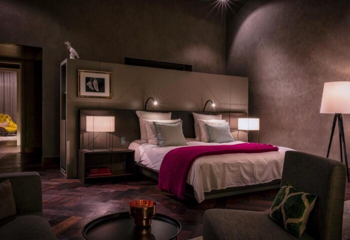 SO/ Berlin Das Stue gay-friendly hotel room. Pet-friendly hotel with a bed, bedside tables, lamps, and a chair. Luxury gay travel.