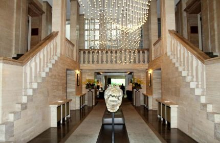 SO/ Berlin Das Stue's grand lobby. Pet-friendly, gay-friendly hotel with striking design. Alligator skull sculpture, stairs, & chandelier.