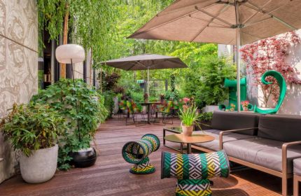 SO/ Berlin Das Stue gay-friendly hotel's pet-friendly outdoor terrace. Lush greenery, stylish seating, and a relaxed atmosphere. Ideal for gay travel.