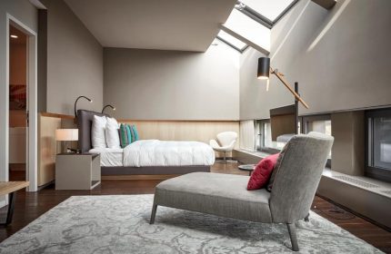 SO/ Berlin Das Stue gay-friendly hotel room. Pet-friendly room with a bed, chaise lounge, and skylight. Modern interior design. Berlin travel.