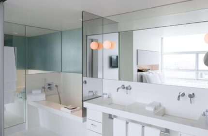 SO/ Vienna gay-friendly hotel bathroom. Modern design with white fixtures, large mirrors, and a sleek bathtub. Ideal for gay men's travel in Vienna.