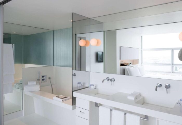 SO/ Vienna gay-friendly hotel bathroom. Modern design with white fixtures, large mirrors, and a sleek bathtub. Ideal for gay men's travel in Vienna.