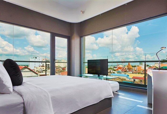 SUN & MOON Urban Hotel room. Gay-friendly hotel with city view. Modern design, bed, TV, and large windows. Ideal for gay men travel.