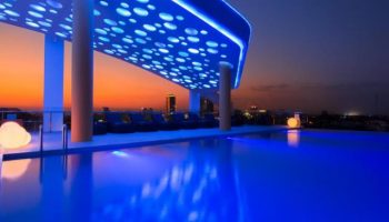 SUN & MOON Urban Hotel's rooftop pool at dusk. This gay-friendly hotel features a stylish design and city views, perfect for gay travelers.
