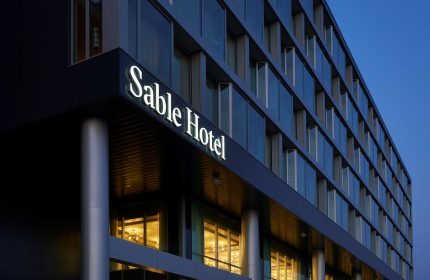 Sable at Navy Pier Chicago, a gay-friendly Curio Collection by Hilton hotel. Exterior view of the Sable Hotel at dusk.