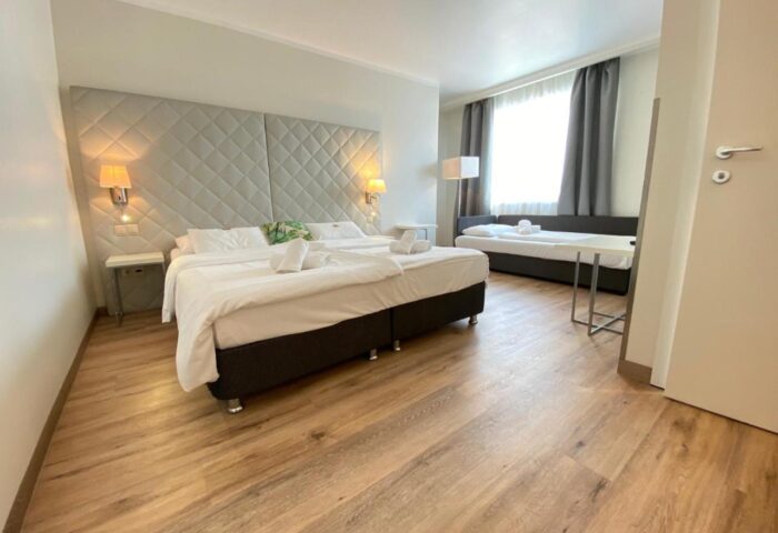 Safestay Vienna hotel room. Gay-friendly lodging with a double bed, sofa, and modern decor. A comfortable stay for gay travelers in Vienna.