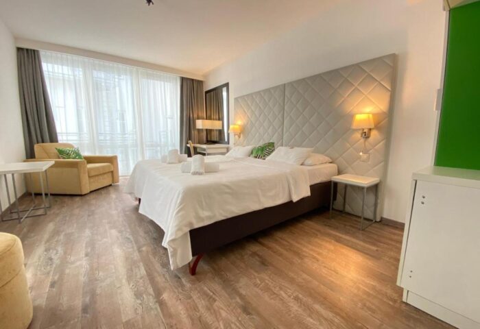 Safestay Vienna hotel room. Gay-friendly accommodation with a double bed, armchair, and desk. A comfortable stay in Vienna, Austria.