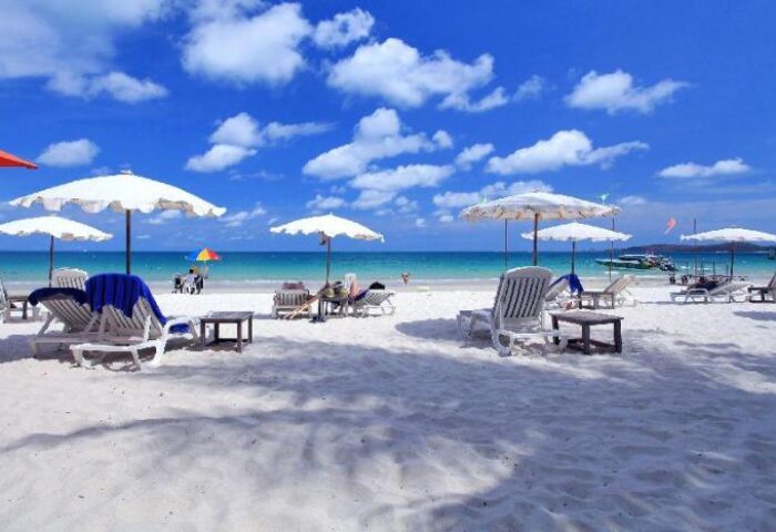 Sai Kaew Beach Resort: Beach chairs and umbrellas on white sand. Gay-friendly hotel with clear blue water and sky. Perfect for gay travel.