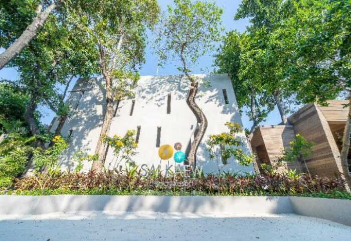 Sai Kaew Beach Resort entrance. Gay-friendly hotel with modern design, trees, and tropical plants. A welcoming destination for gay travelers.