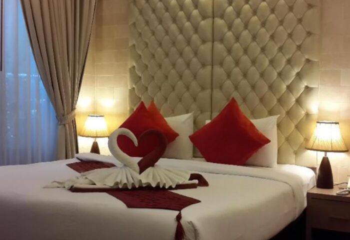 Gay-Friendly Hotel Samed Pavilion Resort: Bed with swan towels and heart. Red pillows. Luxury headboard. Romantic setting. Gay travel.