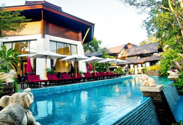 Samed Pavilion Resort pool view. Gay-friendly hotel with sun loungers, umbrellas, and elephant statues. Ideal for gay men travel.
