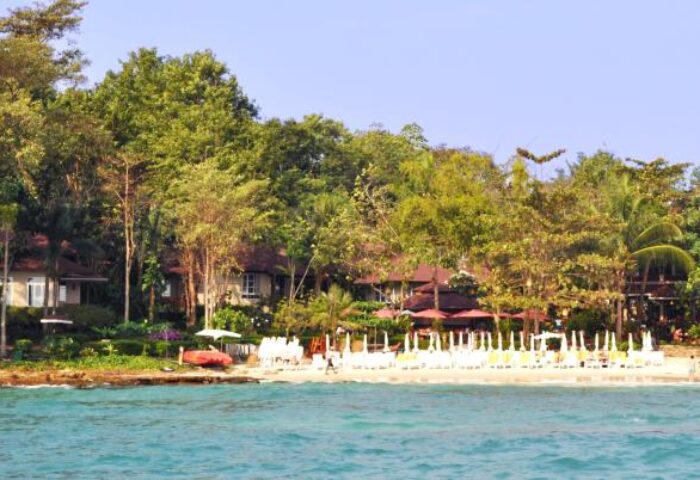 Samed Villa Resort: Gay-friendly hotel view. Beachfront villas with umbrellas, trees, and turquoise water. Ideal gay travel destination.