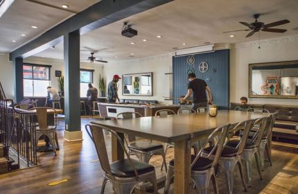 Samesun Hollywood, formerly Walk of Fame Hostel, gay-friendly hotel. Interior view with pool table, dining table, and guests. Relaxed atmosphere.