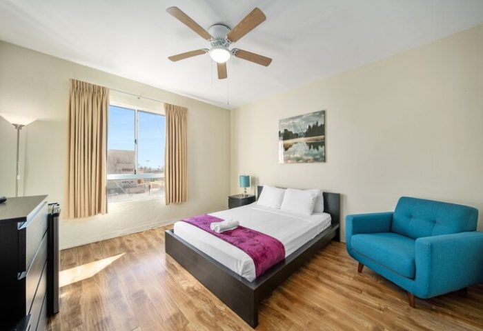 Samesun Hollywood (formerly Walk of Fame Hostel) gay-friendly hotel room. Features a bed, chair, ceiling fan and a view. Great for gay travel.