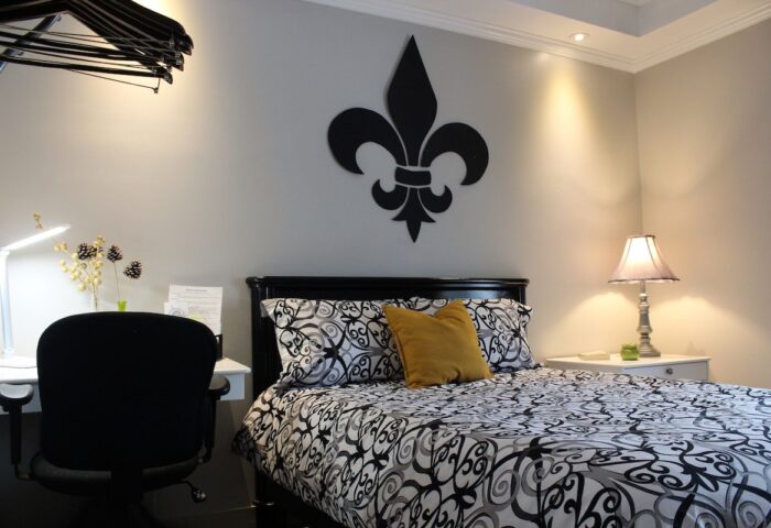 Samesun Montreal Central gay-friendly hotel room. Bed with fleur-de-lis decor, desk, and lamp. Ideal for gay men travelers.