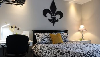 Samesun Montreal Central gay-friendly hotel room. Bed with fleur-de-lis decor, desk, and lamp. Ideal for gay men travelers.
