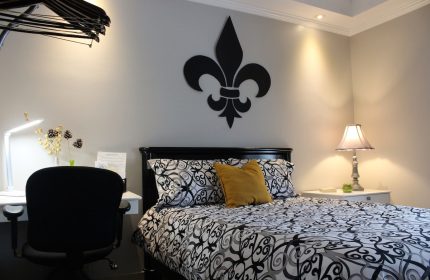 Samesun Montreal Central gay-friendly hotel room. Bed with fleur-de-lis decor, desk, and lamp. Ideal for gay men travelers.