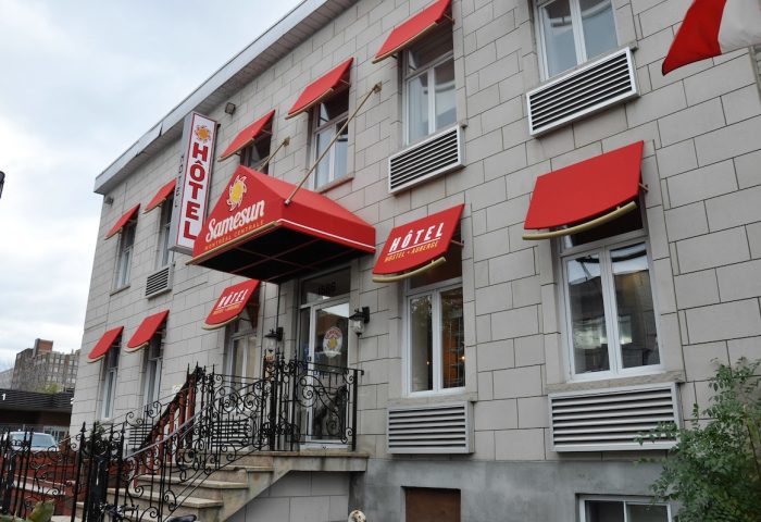 Samesun Montreal Central, a gay-friendly hotel. Exterior view of the building with red awnings. A great choice for gay travelers in Montreal.