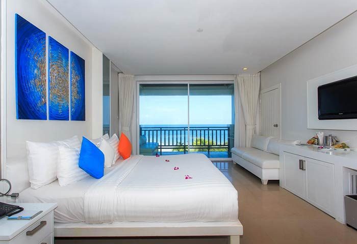 Samui Resotel Beach Resort gay-friendly hotel room. Ocean view from balcony. King bed with colorful pillows and rose petals. Modern decor.