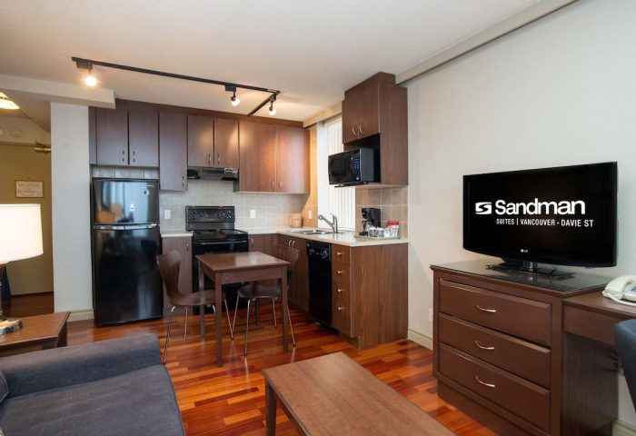 Sandman Suites Vancouver - Davie Street gay-friendly hotel room with kitchen, TV, and seating area. Ideal for gay men travel.