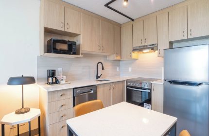 Sandman Suites Vancouver Davie Street kitchenette. Gay-friendly hotel with microwave, stove, fridge, and dining table. Vancouver travel.