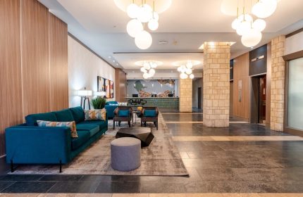 Sandman Suites Vancouver Davie Street lobby. Gay-friendly hotel with modern decor, seating area, and front desk. Ideal for gay travel.