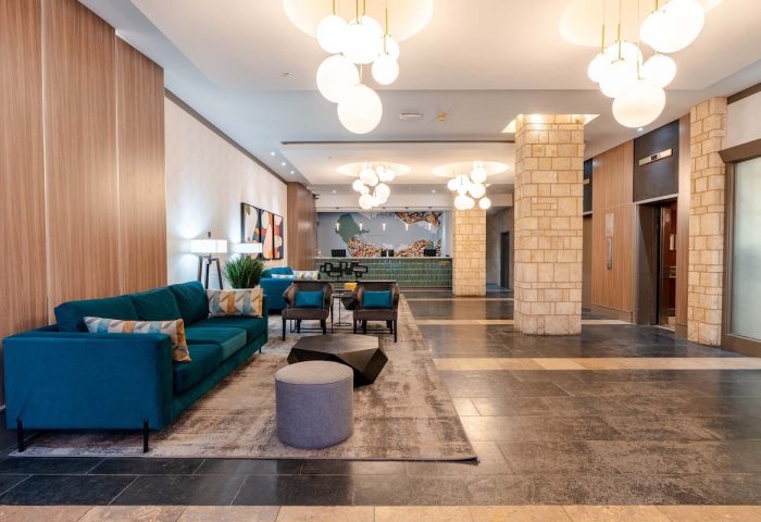 Sandman Suites Vancouver Davie Street lobby. Gay-friendly hotel with modern decor, seating area, and front desk. Ideal for gay travel.