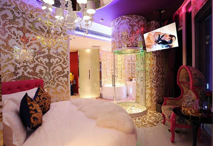 Sanlitun Mark Jacobs Boutique Hotel room. Round bed, mosaic walls, glass shower, and TV. Gay-friendly hotel for gay men travel advice.