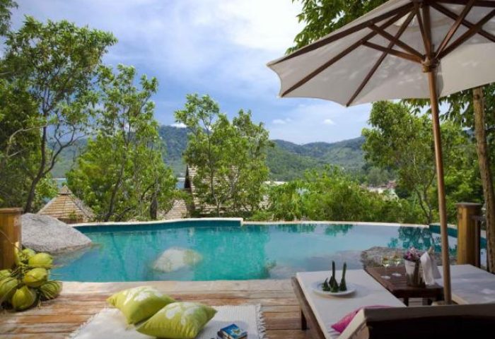 Santhiya Koh Phangan Resort & Spa pool view. Gay-friendly hotel with infinity pool, lounge chairs, and tropical scenery. Perfect for gay travel.