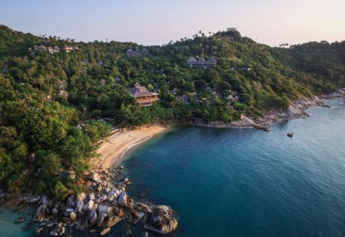 Aerial view of Santhiya Koh Phangan Resort & Spa, a gay-friendly hotel. Lush greenery meets turquoise waters on this Thailand paradise.