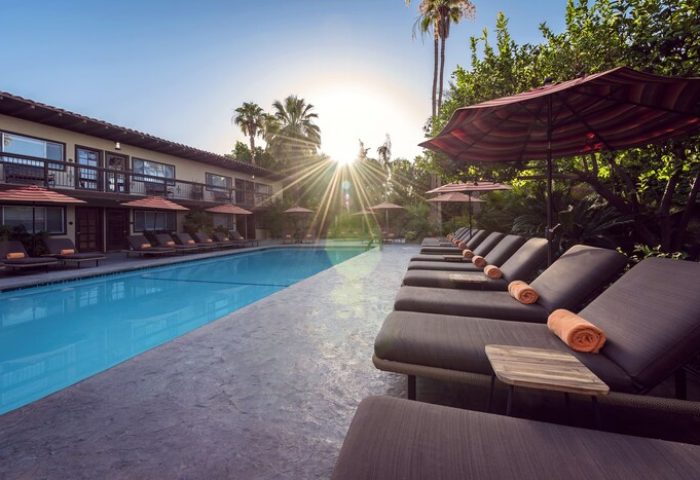 Santiago Resort, Palm Springs Premier Gay Men’s Resort pool view. Gay-friendly hotel with lounge chairs and umbrellas by the pool.
