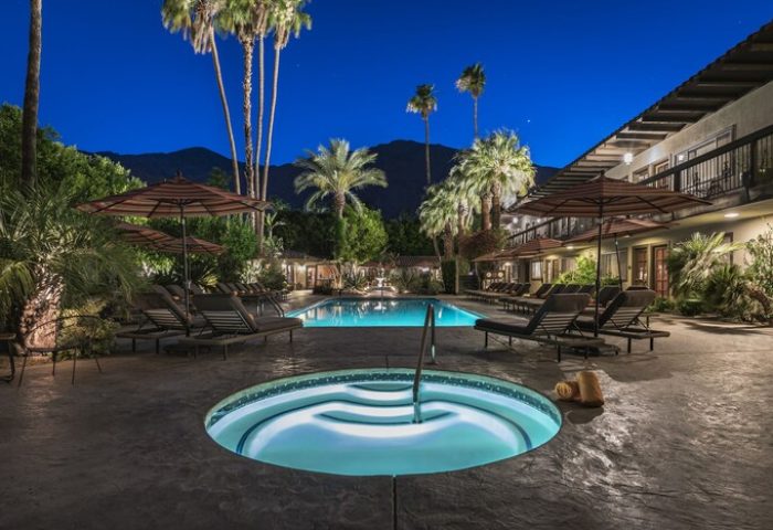 Santiago Resort, Palm Springs: Gay-friendly hotel with a pool and jacuzzi under palm trees at night. Premier gay men's resort for relaxation.