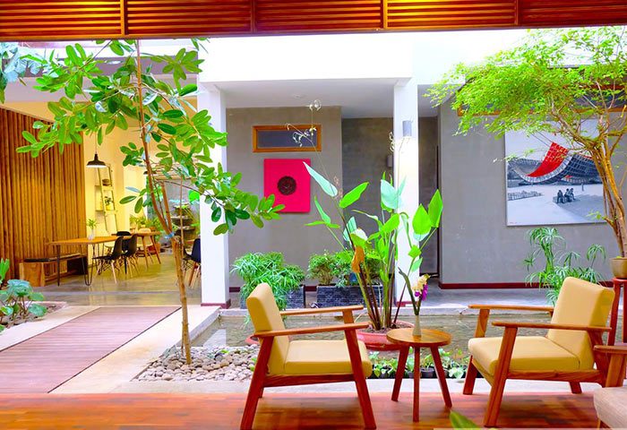 Saravoan Royal Palace's interior courtyard. Gay-friendly hotel with seating, plants, and art. A relaxing space for gay travelers.