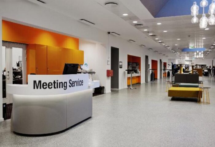 Scandic Copenhagen's stylish lobby. This gay-friendly, pet-friendly hotel features a modern reception area and vibrant orange accents, perfect for gay travelers.