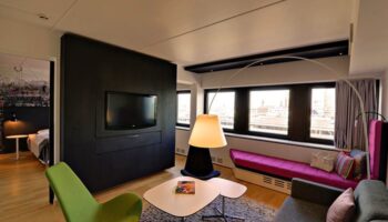 Scandic Copenhagen hotel room. Gay-friendly, pet-friendly hotel with a modern design. Features a TV, seating area, and city views.