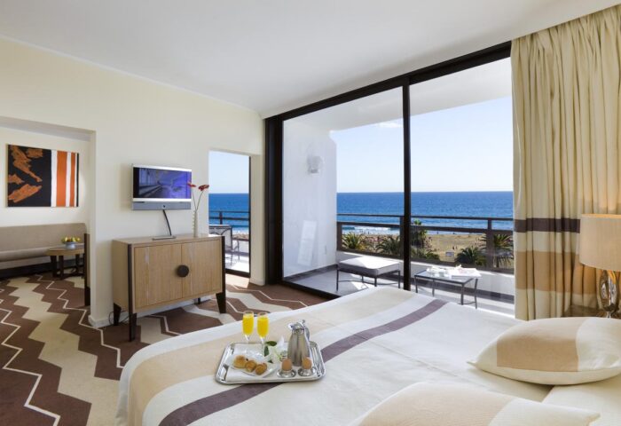 Seaside Palm Beach hotel room. Gay-friendly hotel with ocean view. Balcony, breakfast tray, and modern decor. A luxury stay for gay travelers.