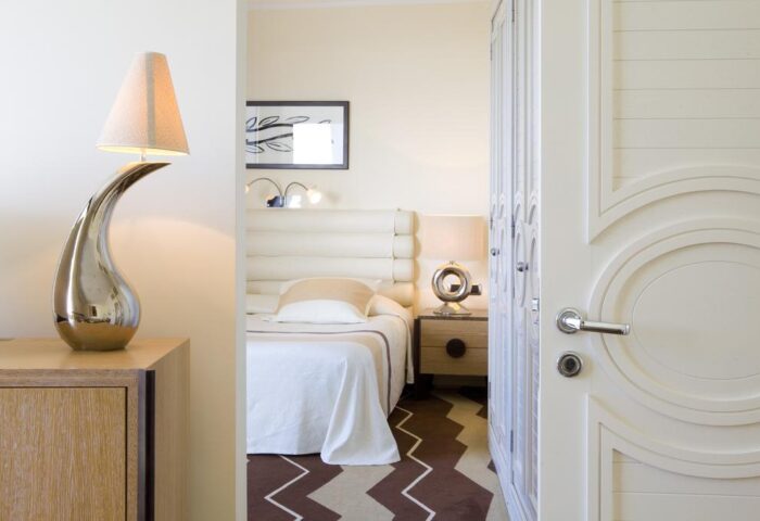 Seaside Palm Beach gay-friendly hotel room. Modern decor, bed, stylish lamps. Luxurious gay travel accommodations and design details.