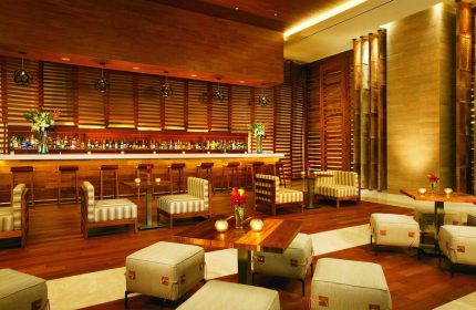 Secrets The Vine Cancun Resort & Spa bar area. All-inclusive, adults-only, gay-friendly hotel. Upscale interior with wood accents.