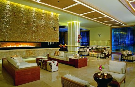 Secrets The Vine Cancun Resort & Spa lobby. Gay-friendly, all-inclusive, adults-only hotel interior with fireplace and seating area.
