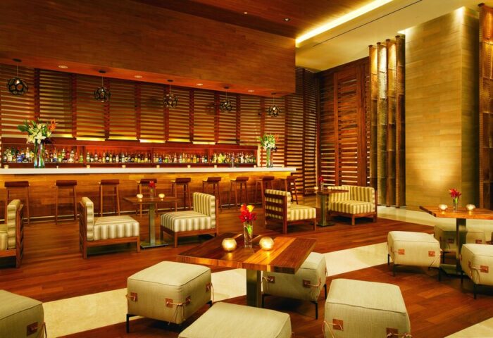 Secrets The Vine Cancun Resort & Spa bar area. All-inclusive, adults-only, gay-friendly hotel with stylish wood decor and seating.