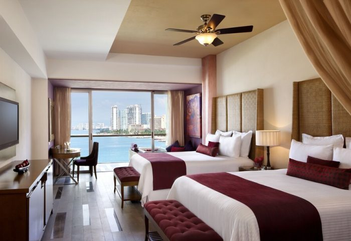 Secrets Vallarta Bay Resort all-inclusive adults-only room. Gay-friendly hotel with ocean view. Two beds, luxury travel.