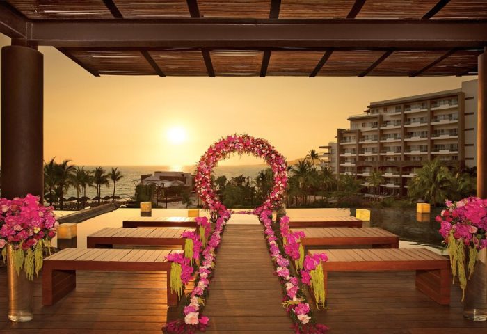 Secrets Vallarta Bay Resort all-inclusive adults-only gay-friendly hotel wedding venue. Sunset ocean view with floral decorations.