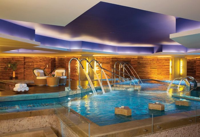 Secrets Vallarta Bay Resort All-Inclusive Adults-Only gay-friendly hotel indoor pool with waterfalls and lounge chairs, for gay men travel.