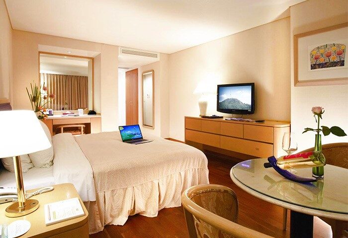 Sejong Hotel Seoul Myeongdong guest room. Laptop on bed, wine, and TV. Gay-friendly hotel in Seoul for gay men travel advice.
