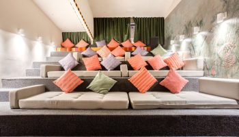 Selina Cancun Laguna Hotel Zone's gay-friendly space. Tiered seating with colorful pillows offers a relaxed, communal vibe. Perfect for gay travel.