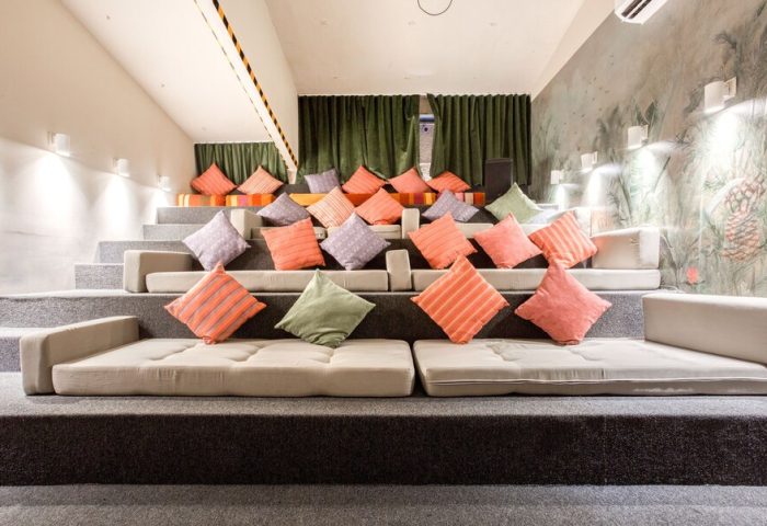 Selina Cancun Laguna Hotel Zone's gay-friendly space. Tiered seating with colorful pillows offers a relaxed, communal vibe. Perfect for gay travel.